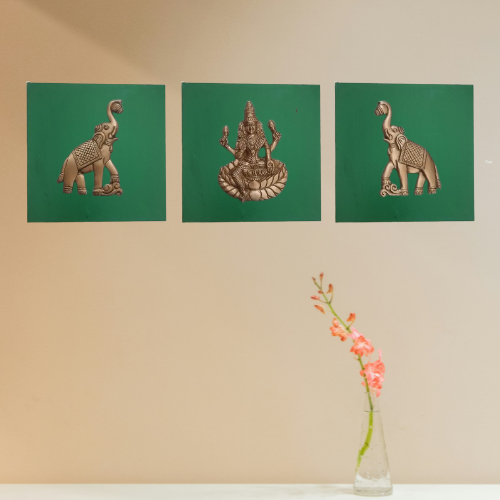 Three decorative panels with elephant and deity designs on a green painted wooden background